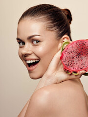 Happy woman holding up a slice of juicy watermelon in front of her smiling face on a sunny day