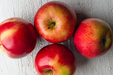 Four Polish red apples on a rustic background