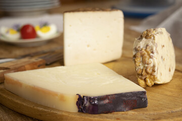 chopping board of various cheeses