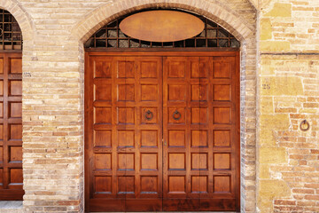 richly crafted wooden door with symmetrical panel designs, set within a stone arch, reflecting classic European architecture