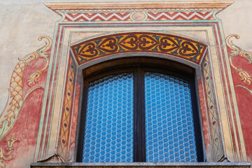 exquisitely decorated window arch featuring vibrant frescoes and blue geometric tiles, showcasing classic European artistry