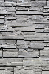 Detail of a wall clad in dark gray stacked stone panels
