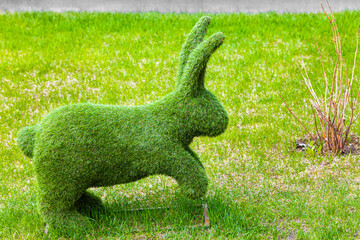landscape figure of a rabbit standing on the lawn.