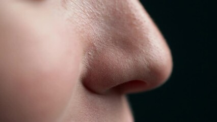 extreme close-up of woman's nose breathing intensely, inhaling and exhaling air.