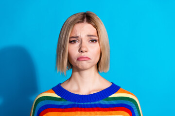 Portrait of pretty young girl sad face wear striped pullover isolated on blue color background