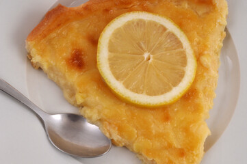 Part de tarte au citron dans une assiette avec une cuillère en gros plan