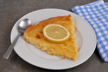 Part de tarte au citron dans une assiette avec une cuillère en gros plan