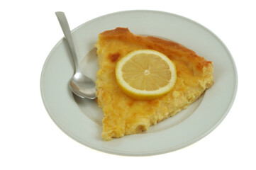 Part de tarte au citron dans une assiette avec une cuillère en gros plan sur fond blanc