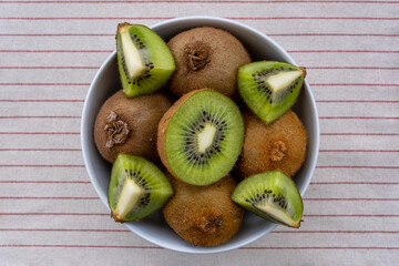 Top view of kiwi fruit in a bowl on the tablecloth
