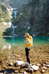 Active woman enjoys the beautiful scenery of the majestic mountains and lake. Travel, adventure. Active life.