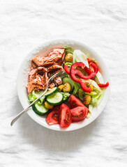 Delicious balanced lunch - grilled salmon, boiled egg, fresh vegetable salad on a light background, top view