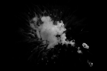 White ink dropped in to water isolated black background. Abstract white color dissolving in water