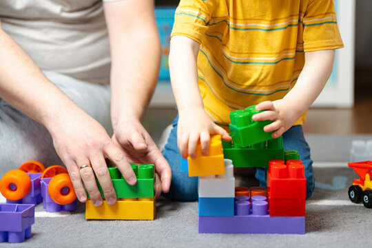 Little toddler boy playing constructor with dad. Spending time with children. Educational activities for kids. Children's room. Indoors