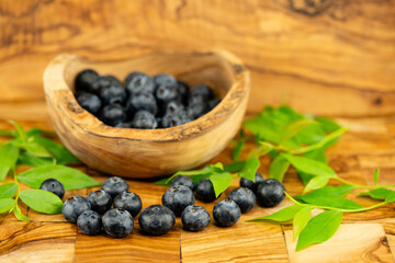 Heidelbeere Vaccinium myrtillus auch Blaubeere genannt auf Olivenholz