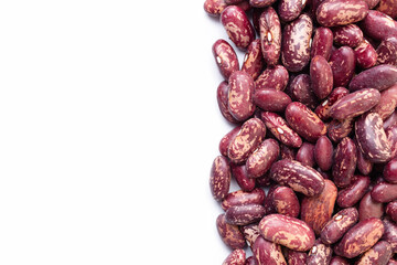 Uncooked, variegated kidney bean seeds border on white background. Copy space for text. Top view
