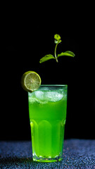 Green beverage with a slice of lime garnish served in a tall glass