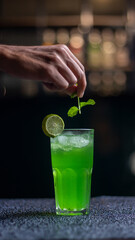 Green beverage with a slice of lime garnish served in a tall glass