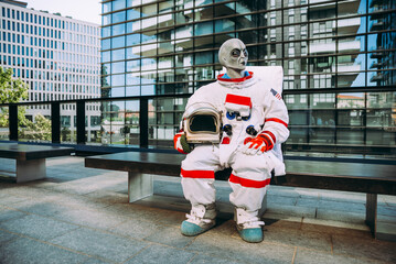 Cinematic fiction image of a modern alien astronaut roaming in a city on planet earth.