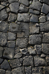 A top-down view of a cobblestone street, with the irregularly shaped stones creating a textured pattern.