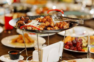 a large served festive table with appetizers. bowl of kebab stand in the center of the table.