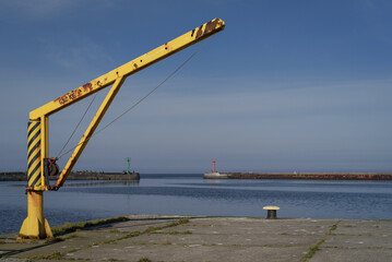 Fototapeta premium MARITIME TRANSPORT - Yellow manual crane on the seaport quay 
