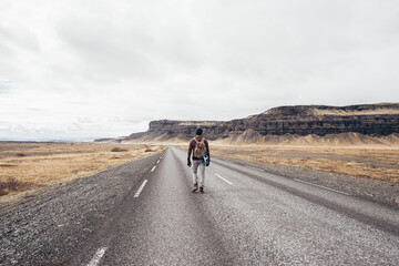 Skater traveling iceland on his longboard. Young man making an adrenaline-filled experience between...