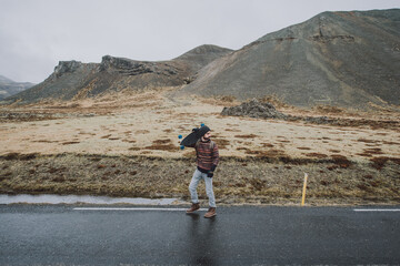 Skater traveling iceland on his longboard. Young man making an adrenaline-filled experience between...
