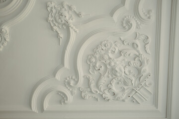 some beautiful white decor on the ceiling in a room with many details