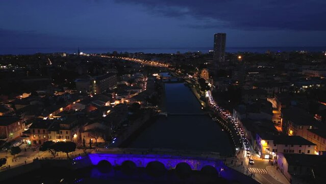 Ascending drone shot of Tiberius Bridge over the Marecchia River in Rimini city, Italy