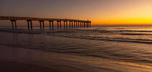 Scenic view of a pier against the backdrop of the vibrant sky at sunset