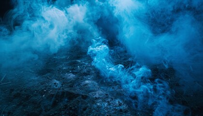 Obraz premium Mystical blue smoke rising from the ground against a dark backdrop, creating a magical and spooky atmosphere, perfect for themes like Halloween and fantasy