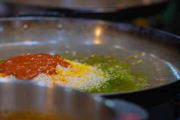 ingredients in the frying pan to prepare a paella. paella ingredients. rice, tomatoes