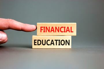 Financial education symbol. Concept words Financial education on beautiful wooden block. Beautiful grey paper background. Businessman hand. Business Financial education concept. Copy space.