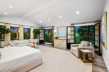 Elegantly furnished bedroom featuring a large four-poster bed, a high ceiling, and glass doors