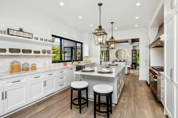 Modern kitchen interior featuring white cabinets and stainless steel appliances