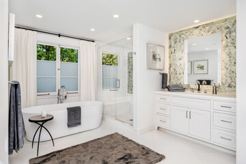 Pristine white bathroom with a large, luxurious bathtub