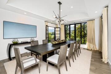 Contemporary white dining room with a sleek table in the center, surrounded by four modern chairs