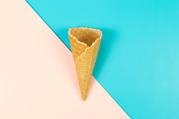 Top view of ice cream waffle cone on colorful background. Summer wallpaper, flat lay, copy space.