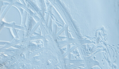 Aerial view of car tire tracks on the fresh snow in the parking lot