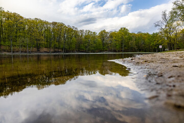 Obraz premium the water is reflecting the sky and trees along the shoreline