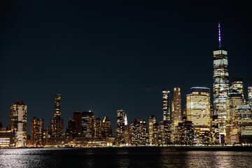 the view of the new york skyline at night, with one world trade center in