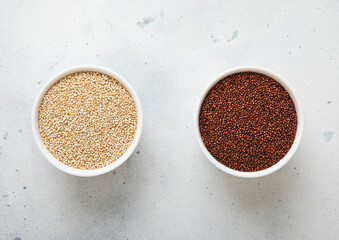 Two bowl plates with white and brown quinoa balanda grain seed on kitchen table.Macro.