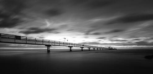 a grayscale shot of the sun setting over the ocean: Baltic Sea, Germany