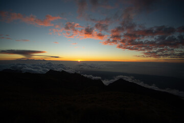 Sunrise above the clouds on a mountain horizon