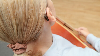 A woman with a hearing aid plays the guitar. I can hear music again! Technologies to assist people...