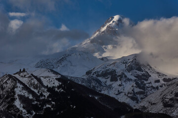 Magnificent Kazbeg mountain in Georgia, with the iconic Gergeti Trinity church in Stepantsminda