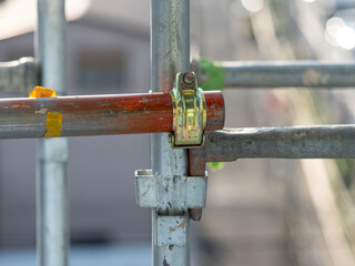 建築現場に設置された足場の単管パイプとクランプ