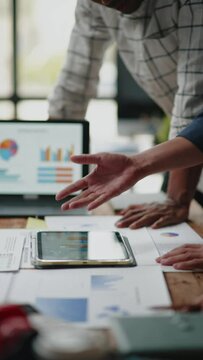 Vertical footage of Close up of hand teamwork business group are meeting working calculate and brainstorming about business financial and marketing on paperwork and presentation.