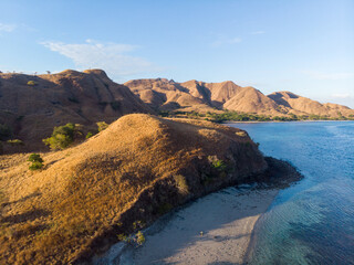 Obraz premium A serene coastal landscape with dry hills and a clear blue sky