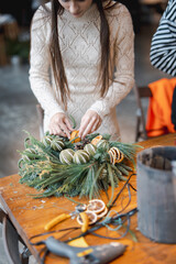 A gorgeous young lady enthusiastically participating in a holiday decoration workshop.
